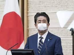 An exiled Tibetan activist wearing a mask in the likeness of Chinese president Xi Jinping sits in a tub filled with red fluid representing blood in Dharmsala