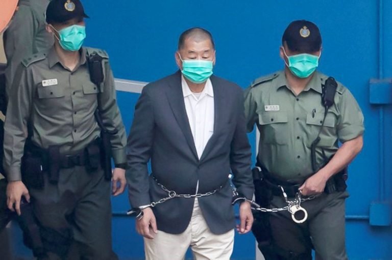 jimmy-lai-founder-of-hong-kongs-pro-democracy-apple-daily-newspaper-is-escorted-by-correctional-service-officers-to-a-prison-van-before-appearing-in-court-in-hong-kong-dec.-12-2020