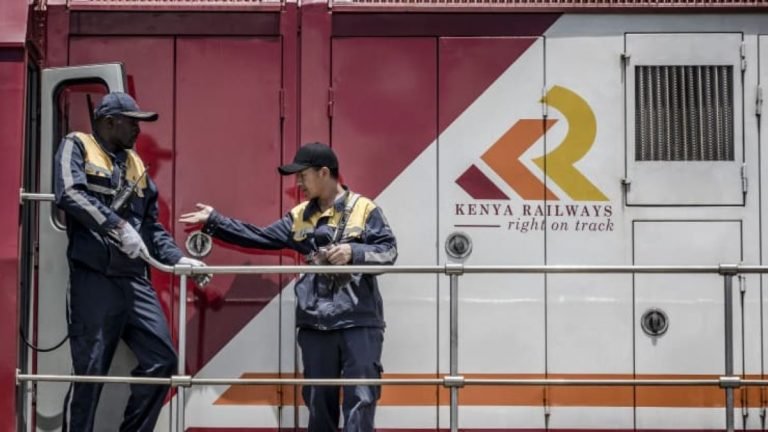 Railway workers inspect a Kenya Railways freight train before departure from the port station in Mombasa, Kenya