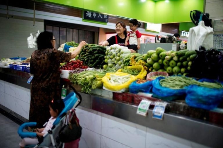 two-grandmothers-with-their-granddaughter-trade-vegetables-at-a-market-on-the-outskirts-of-shanghai